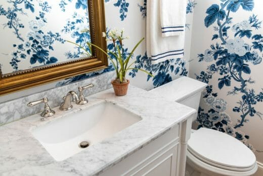 single vanity and blue flowered wallpaper