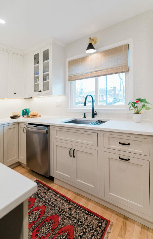 Charleene's-Houses-MD-baltimore-towson-kitchen-renovation-white-cabinets-black-hardware-black-and-brass-sconce-above-sink-black-faucet